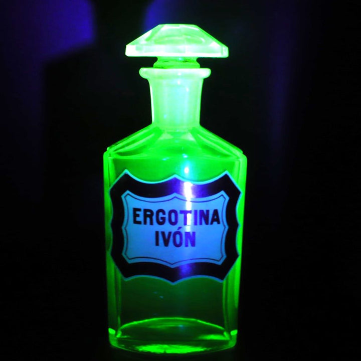 Uranium glass apothecary jar glowing under uv light.