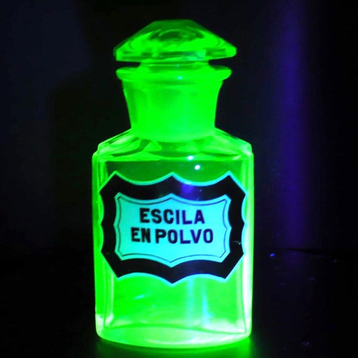 Uranium glass apothecary bottle glowing under uv light.