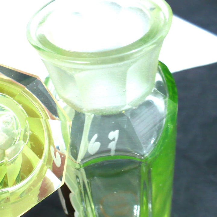 Uranium glass apothecary bottle under regular light showing matching etched numbers.