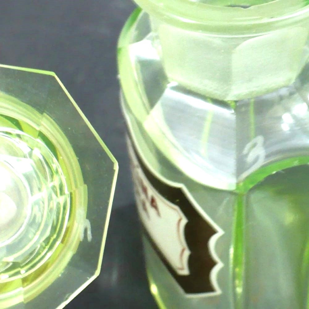 Uranium glass apothecary bottle under regular light showing matching etched numbers.