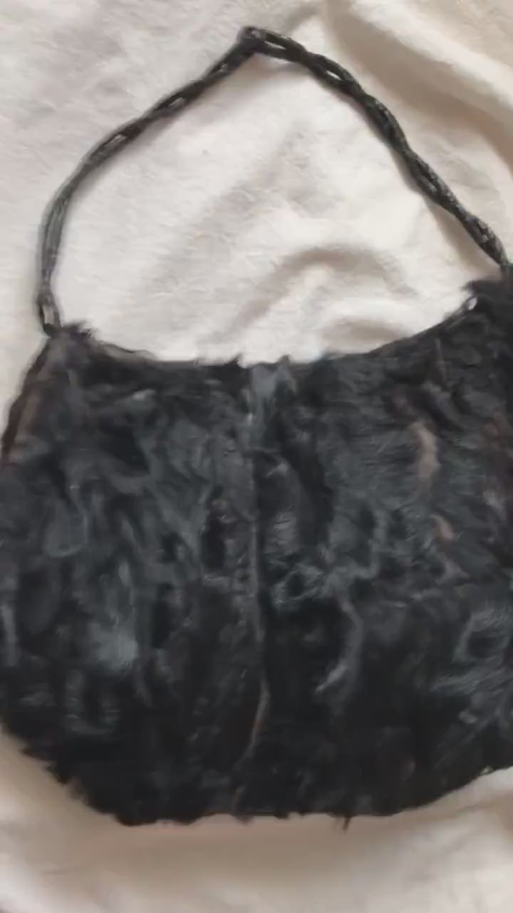 video shows a hand moving the muff purse. It shoes the handle. It shows both sides of the muff, the opening for your hands, unzips the coin purse compartment, opens the coin purse.  